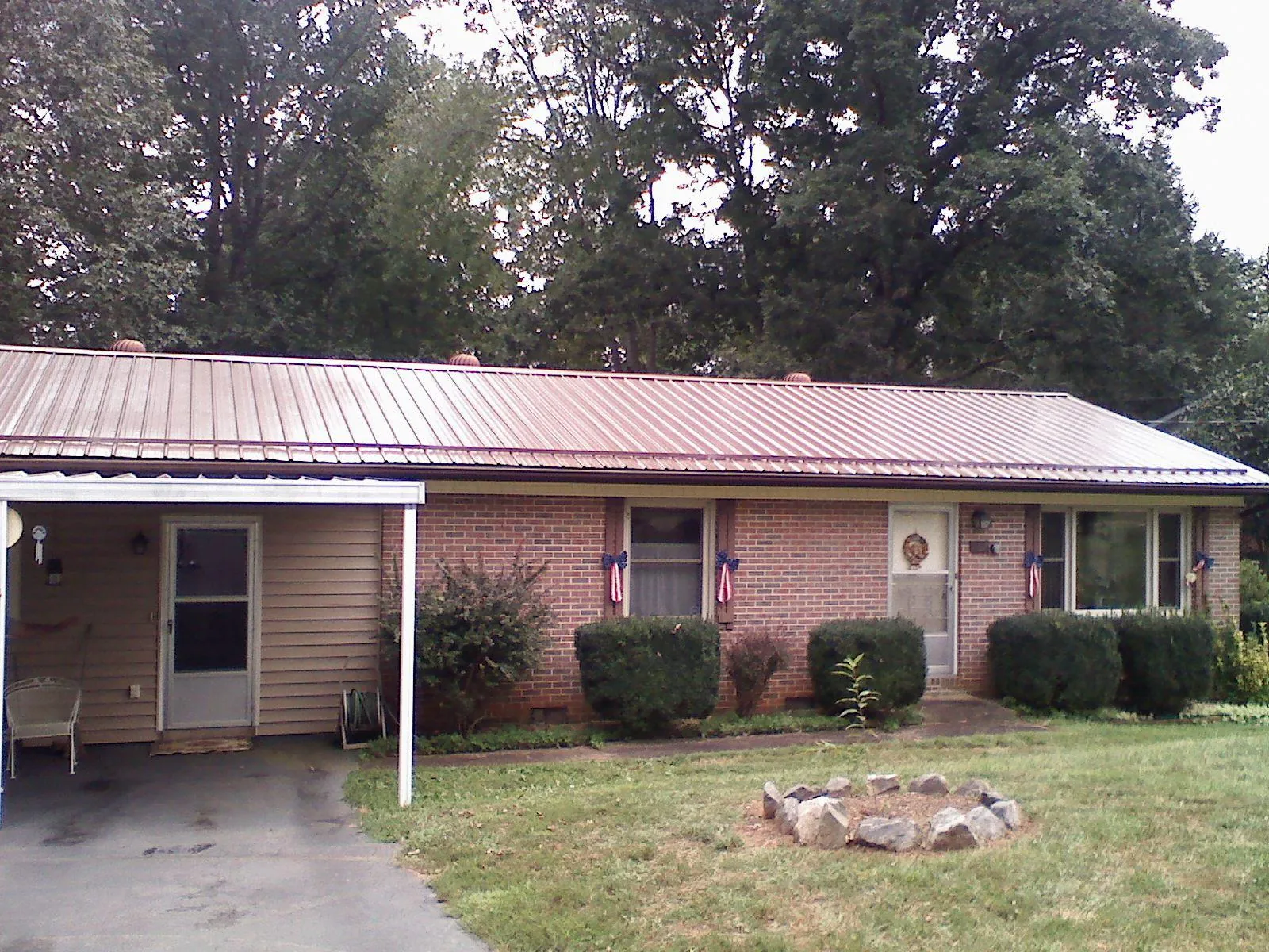 Bronze metal roof and carport on a brick ranch home — Roof Repair work by our crew in South Hill